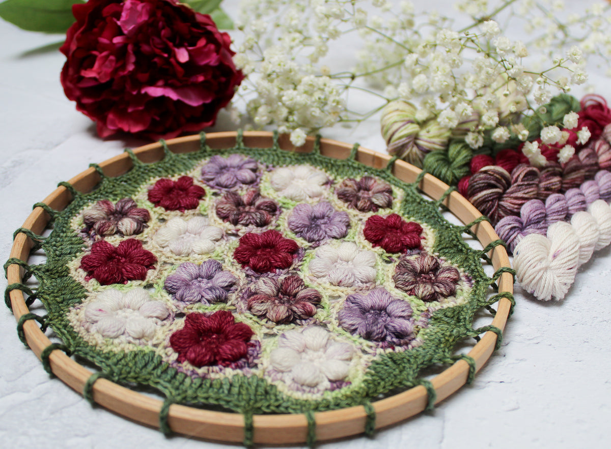 Peony Blossom hoop with a beautiful deep plum coloured flower, some baby's breath and the yarns used to make it.