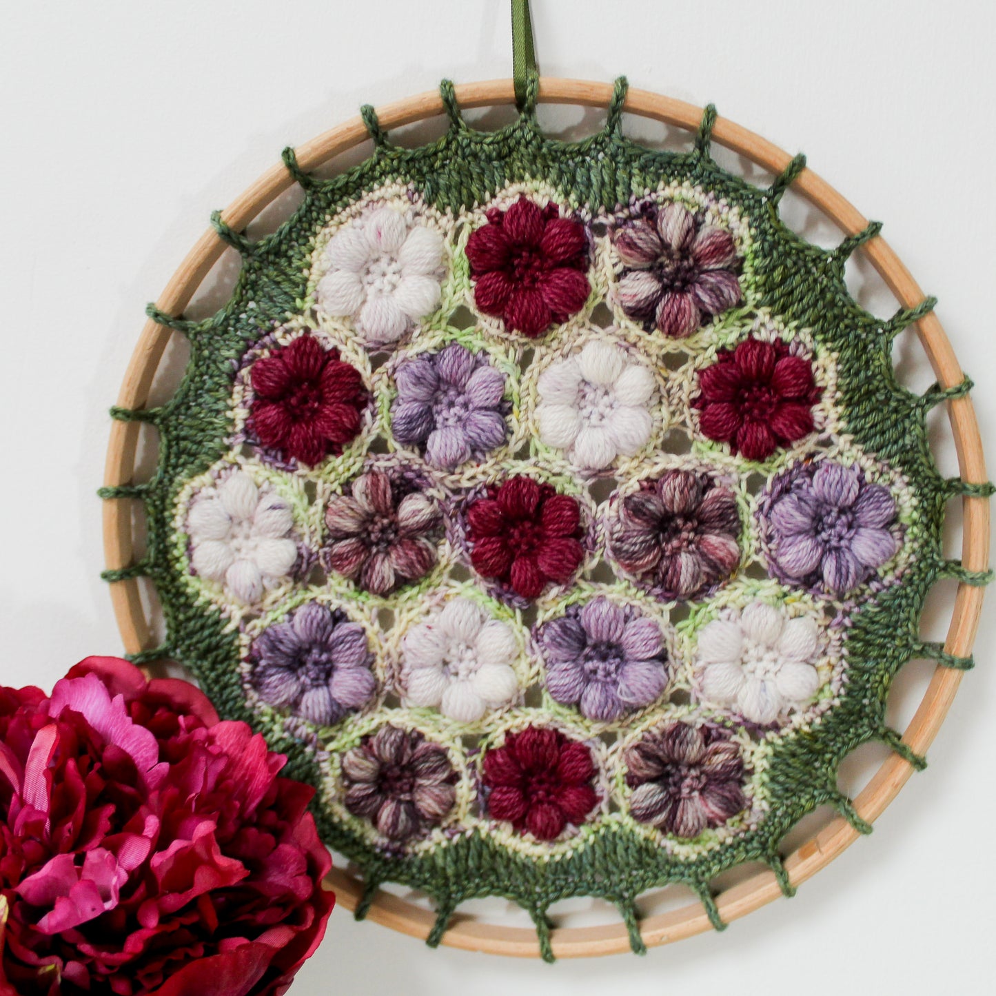 Peony Blossom hoop against a wall with a beautiful deep plum coloured flower