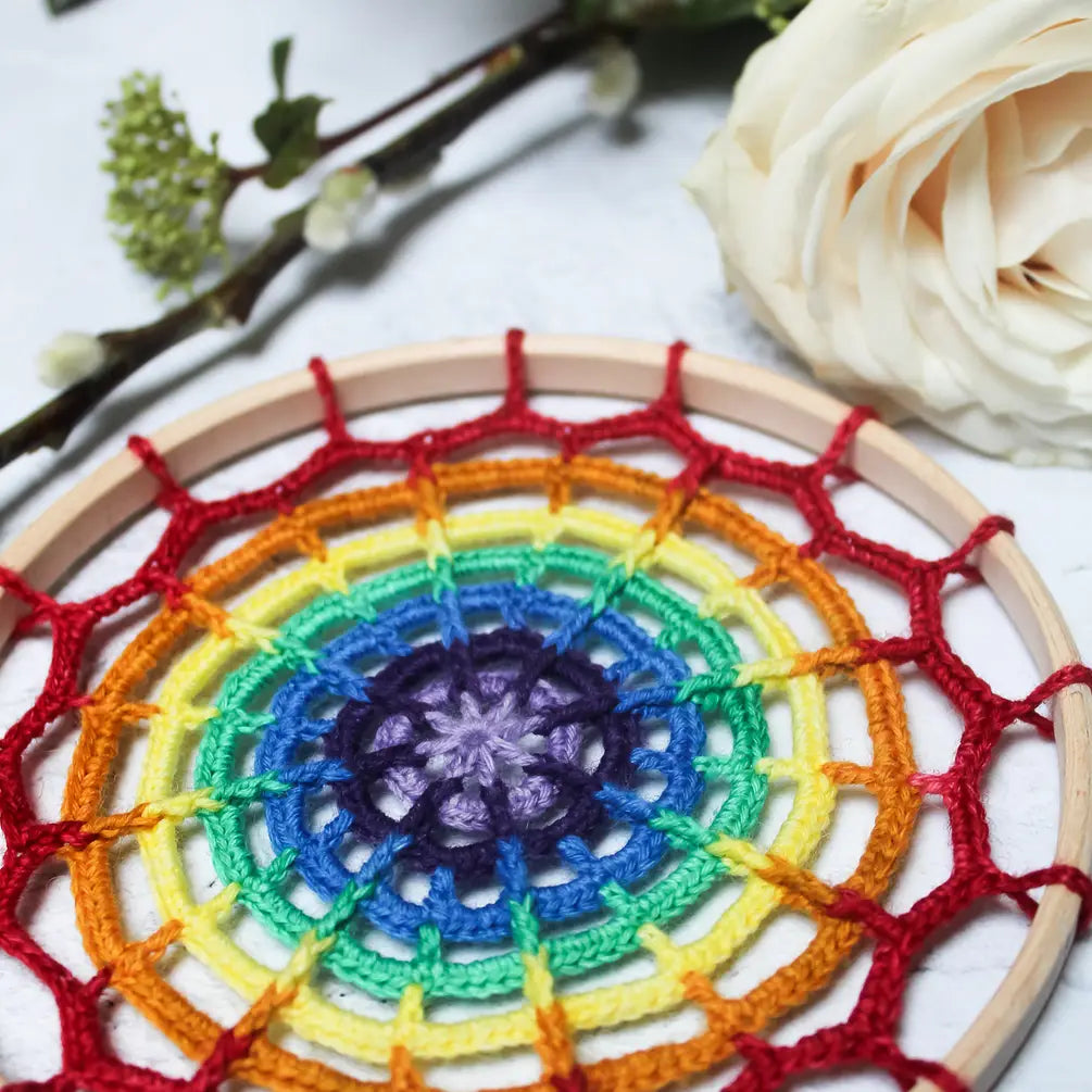 Rainbow Mandala will a white flower in the background
